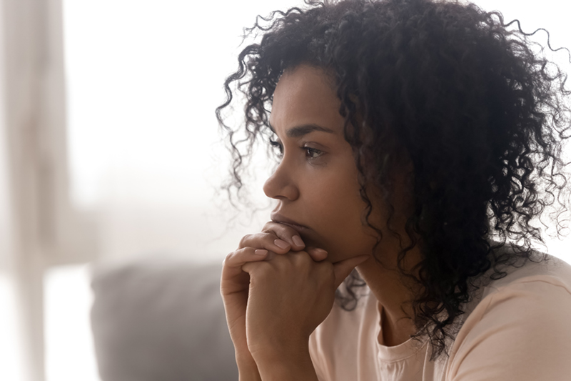 woman looking off to side in contemplation.